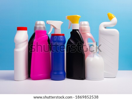 Various cleaning supplies, detergents and cleaning products on blue background.
