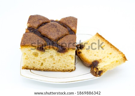 Festive cake with jam on a white plate in close-up on a white background