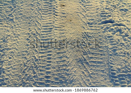 Tire tracks left in the snow on a bright sunny day. The concept of snow removal, ski resorts, active winter vacations. Stock photo with empty space for text and design