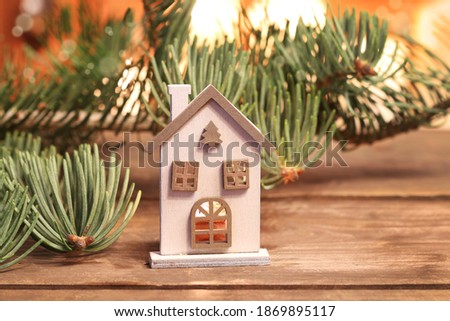 Christmas decoration with wooden house, fir branches and candles. 