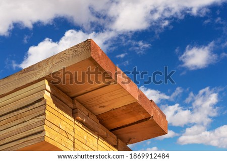 Stack of dimensional lumber for home construction with partly cloudy sky.  Royalty-Free Stock Photo #1869912484
