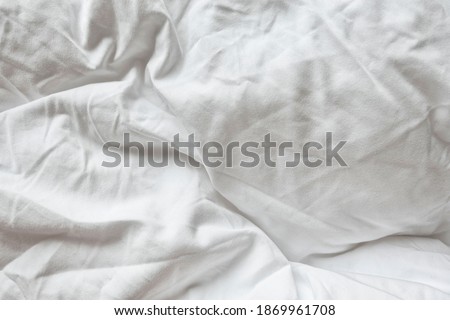 White Natural Cotton Sheet Bed Material Close-up. Unmade Hotel Bed Pillow Texture. Crumpled Messy Blanket In Home Bedroom.