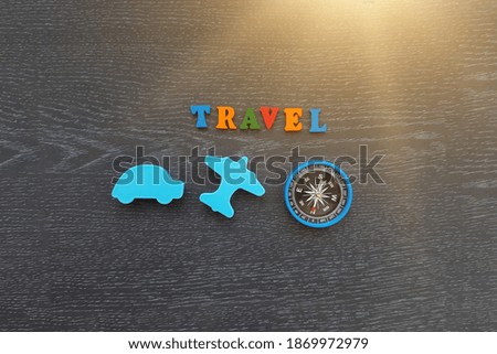 Car, plane in blue, compass, word travel on a dark background.  Travel, recreation, tourism. Outdoor activity.