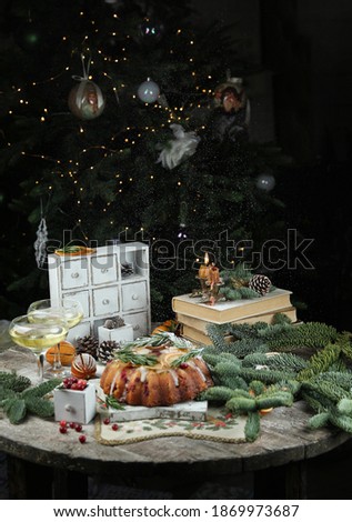 Christmas and new year. Christmas cake on a wooden table, gifts, books, fir branches, cones, drinks and snow. Background image, ?opy space, vertical