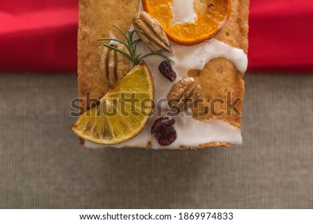 
Glazed bread with walnut and blueberry on brown and red background