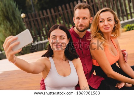 Caucasian three adult friends taking selfie during training in fitness outfit outdoors