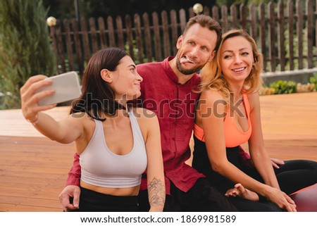 Happy fit friends taking selfie during workout outdoors in sporty outfit