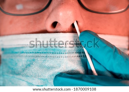 Close-up of epidemiologist taking an uncomfortable PCR test of a male patient during COIVD-19 outbreak. Selective focus Royalty-Free Stock Photo #1870009108