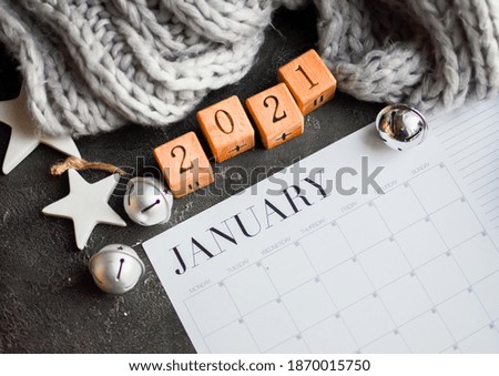 2020 year-end review, date planning, appointment, deadline or holiday concept on the wooden table next to the black clean calendar on the month of January 2021.