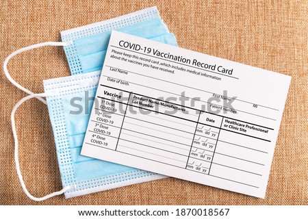 Coronavirus vaccination record card. Protective mask divided into two parts. Concept of defeating Covid-19 Royalty-Free Stock Photo #1870018567