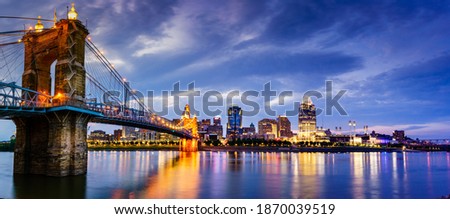 Nighttime panoramic view of John A. Roebling Suspension Bridge over the Ohio River and downtown Cincinnati skyline