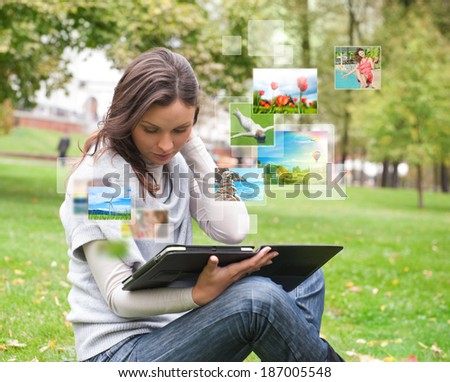 Portrait of young happy woman sharing her photo and video files in social media resources using her modern tablet computer