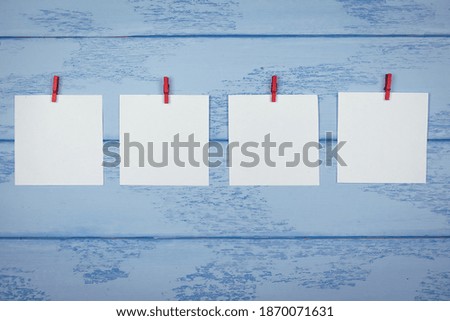 Mock up: four white stickers with red clothespins on the blue boards.