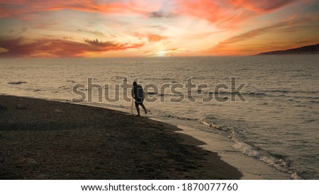 Man fishing on beach with fishing net at beautiful sunset. One of the most popular retirement activity. Peace, fun, relaxation conceptual photo. Mountains on background.  