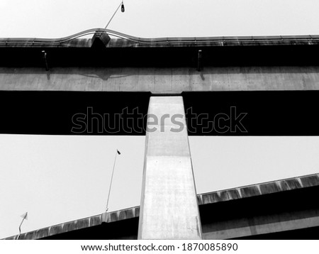 A close-up of the viaduct concrete bridge pillar arch structure, supporting structure and pillars. (Black and white photo)