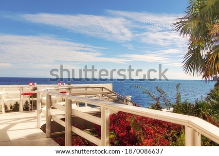 Landscape Of Outdoor White Wooden Summer Terrace And Decking With Seascape View. Beach Resort Alfresco Cafe Or Bar With Sea View. Royalty-Free Stock Photo #1870086637