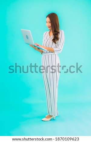 Portrait beautiful young asian woman use computer laptop with blue isolated background