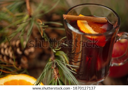 Macro shot view of fragrant Christmas mulled red wine with aromatic spices and citrus fruits on a wooden rustic table with festive composition background. Concept of Christmas time.