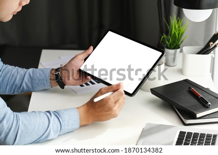 Cropped shot of graphic designer using stylus pen pointing on tablet. Blank screen for product montage.