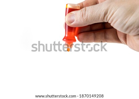 Yellow food coloring bottle being squeezed isolated over white