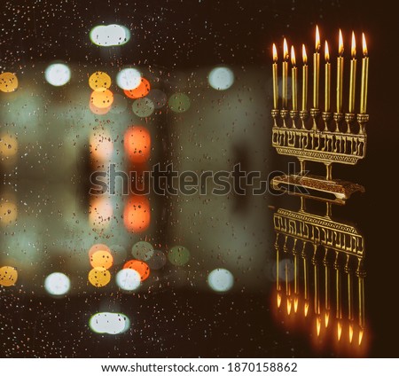 Burning menorah with golden candles and confetti defocused light background. Jewish holiday Hanukkah symbol.