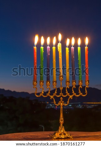 Burning candles are traditional symbols of Hanukkah Holiday of light, selective focus on menorah with candles, blurred night sky background 