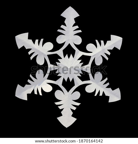 A handmade white paper snowflake isolated on black