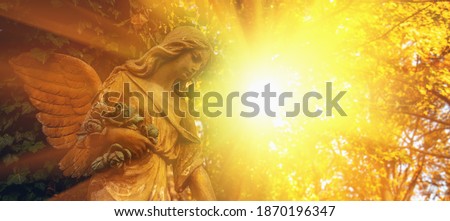 Guardian angel statue in sunlight. Horizontal image.