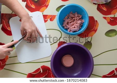 Girl cuts ingredients for olive salad.