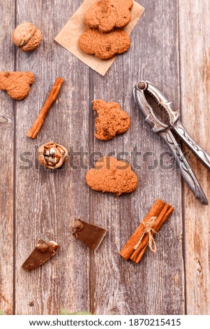 Christmas gingerbread star shaped   cookies and cinnamon sticks ,   on   wooden background with lights . Christmas  card background  