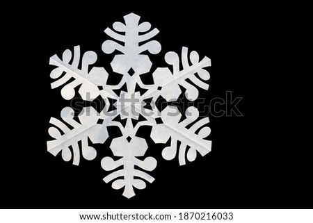 White paper snowflake on black background, copy space. Handmade new year decoration Royalty-Free Stock Photo #1870216033