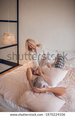 Happy morning. Married couple having fun in bedroom and looking happy