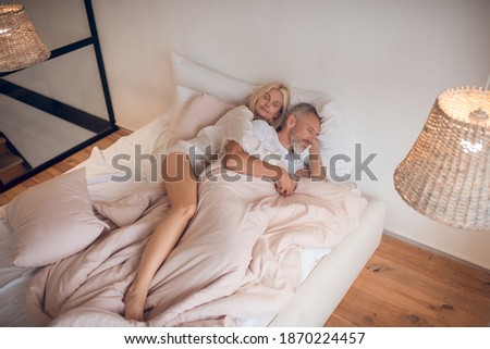Weekend morning. Married couple sleeping peacefully on a bed