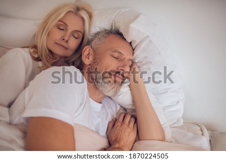 Peaceful. Married couple sleeping on a bed and looking peaceful