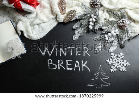 Flat lay composition of Christmas decorations and white knitted plaid on school blackboard with phrase Winter Break