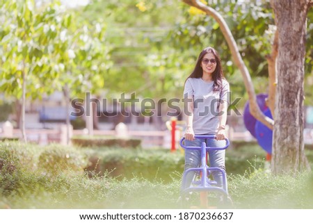 Portrait of beautiful young woman exercising in the park. Asain female fitness model working out in the morning. Confident fitness model in park. Active sporty woman enjoying outdoors in autumn.