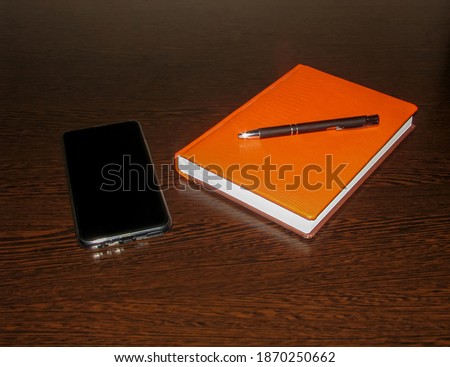 Smartphone with Notepad and pen on the table