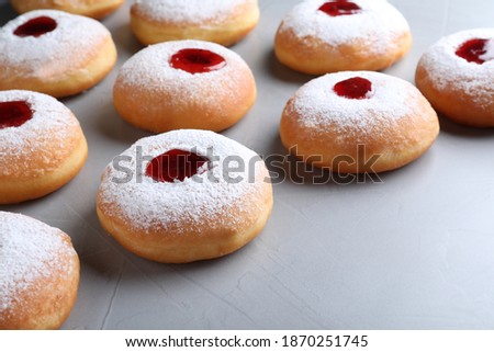 Hanukkah doughnuts with jelly and sugar powder on grey background, closeup