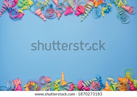 party background with colorful streamers for celebrating birthday. space with scattered confetti. Colorful celebration concept. Copy space on blue background