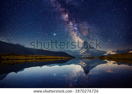 Famous Matterhorn spire under the starry sky. Location Stellisee lake, Cervino peak, Swiss alp, Switzerland, Europe. Photo of popular touristic place. Long exposure shot. Discover the beauty of earth. Royalty-Free Stock Photo #1870276726