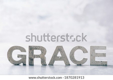 Word GRACE made with cement letters on grey marble background. Copy space. Biblical, spiritual or christian reminder. Royalty-Free Stock Photo #1870281913