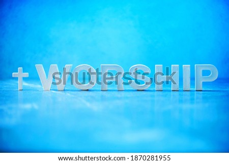 Word Worship made with cement letters on blue marble background. Copy space. Biblical, spiritual or christian reminder. Good friday, Easter day in church. Christian music concert, Sunday service. Royalty-Free Stock Photo #1870281955