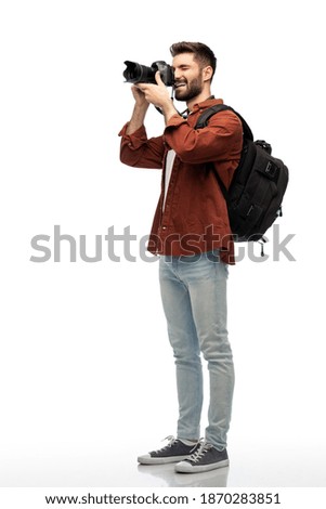photography, travel and people and concept - happy smiling man or photographer with digital camera and backpack taking picture over white background