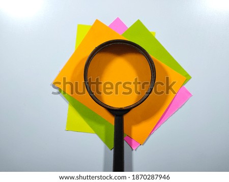 Selective focus.Copy space and text space on colorful paper with magnifying glass on white background.Business and education concept.