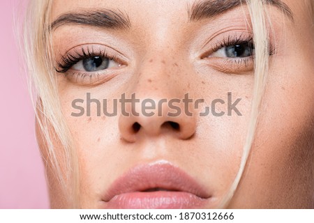 closeup of beautiful blonde woman with freckles isolated on pink Royalty-Free Stock Photo #1870312666