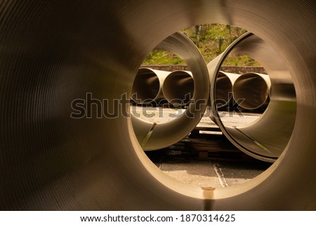 FRP (GRP) pipes are waiting in the field for installation Royalty-Free Stock Photo #1870314625