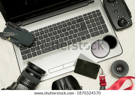 Composition with camera and photo and video production equipment with camera, drone, filters and more accessories on white background, top view.
