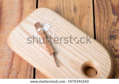 Rock salt with a tool on a wooden table.