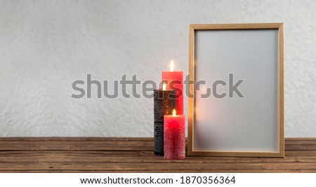 Empty photo frame. Lighted candles. Memory of the victims. On a wooden background