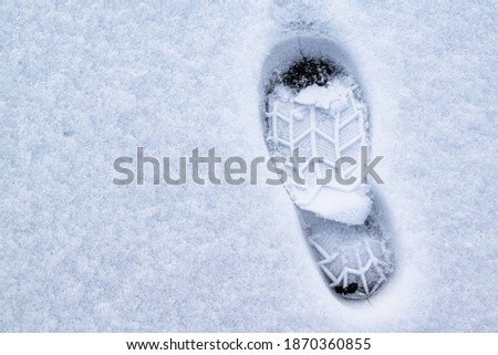Footprint of shoes on ice covered with snow.